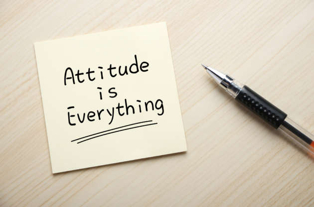 Text Attitude is Everything written on the sticky note with pen aside.